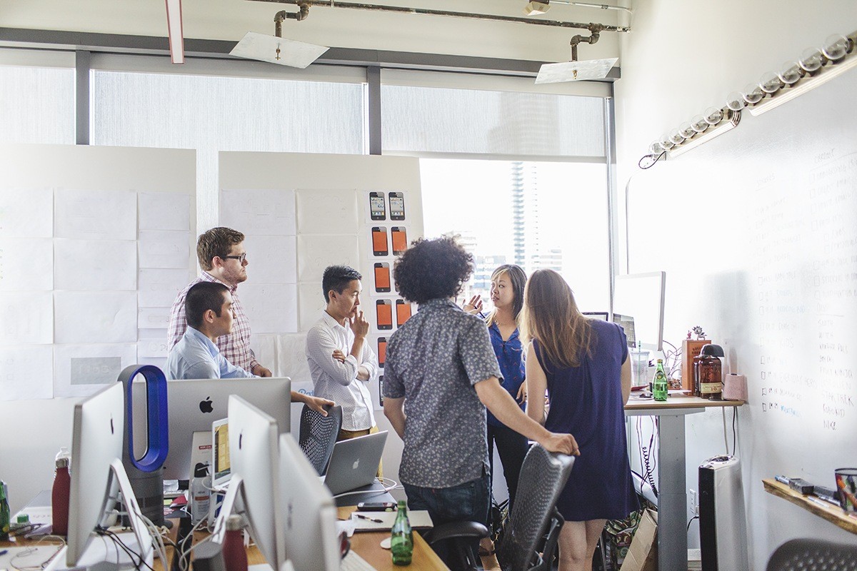 Everyone gets together for their design team meeting. The design team sits together in one room, with a door that they can close. Instead of moving the whole team to a conference room, they just move from their desks to stand by a foam board or hover over someone’s desk.